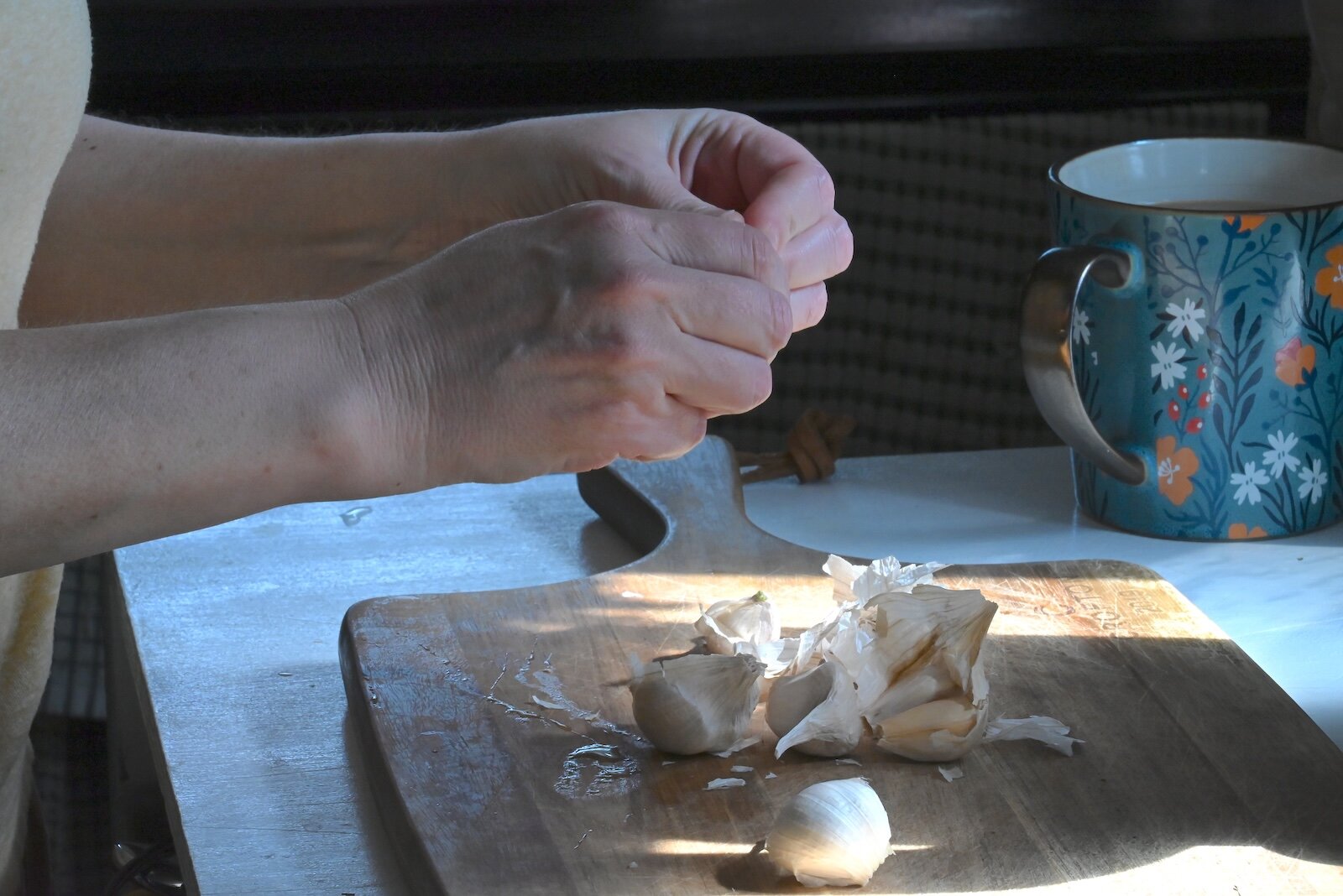 Stacey Kornegay peels garlic for the hummus she is making.