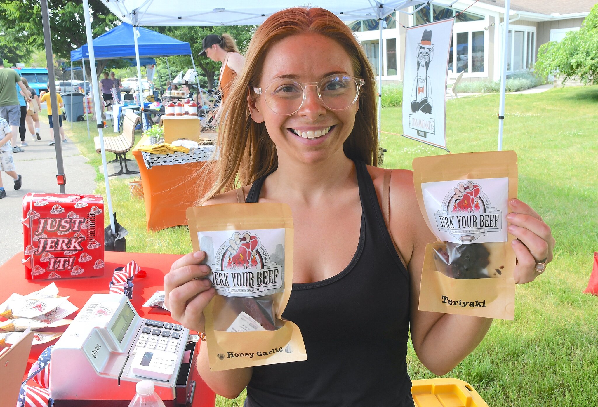 Taylor Sopko holds up some of Jerk Your Beef Jerky’s products for sale at the Richland Farmers Market.