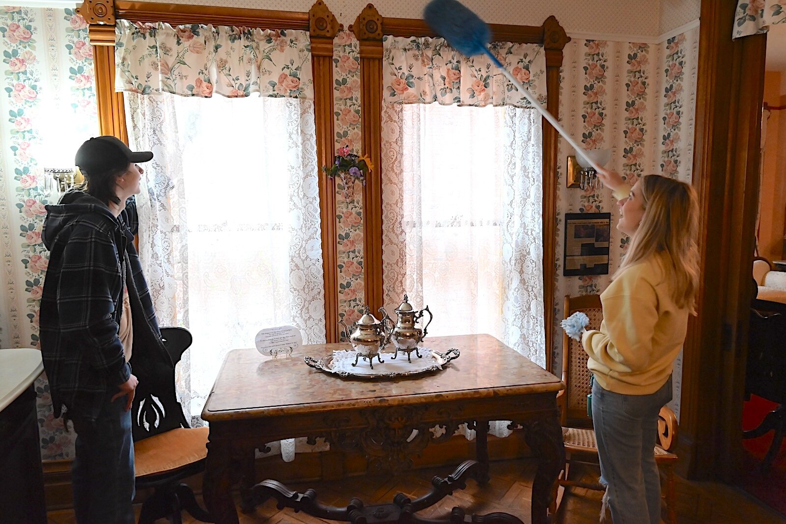 Kellogg Community College students, from left, William Wallen and Kirsten Wedding dust curtains and windows inside Kimball House.
