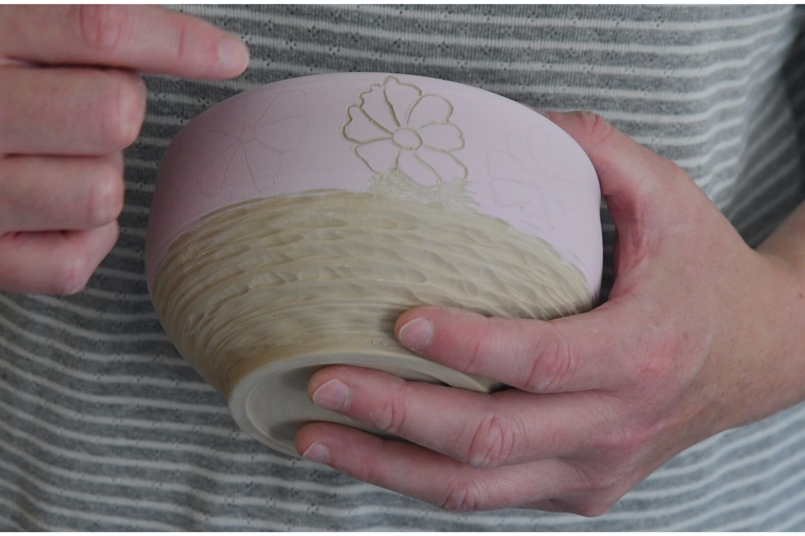Laura points out a piece of artwork on one a bowl she’s making.