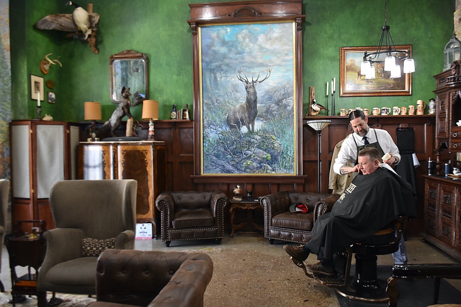Noah Saber works on Richard Morrissette’s hair in the Huntsman’s Hound Lounge in downtown Marshall.