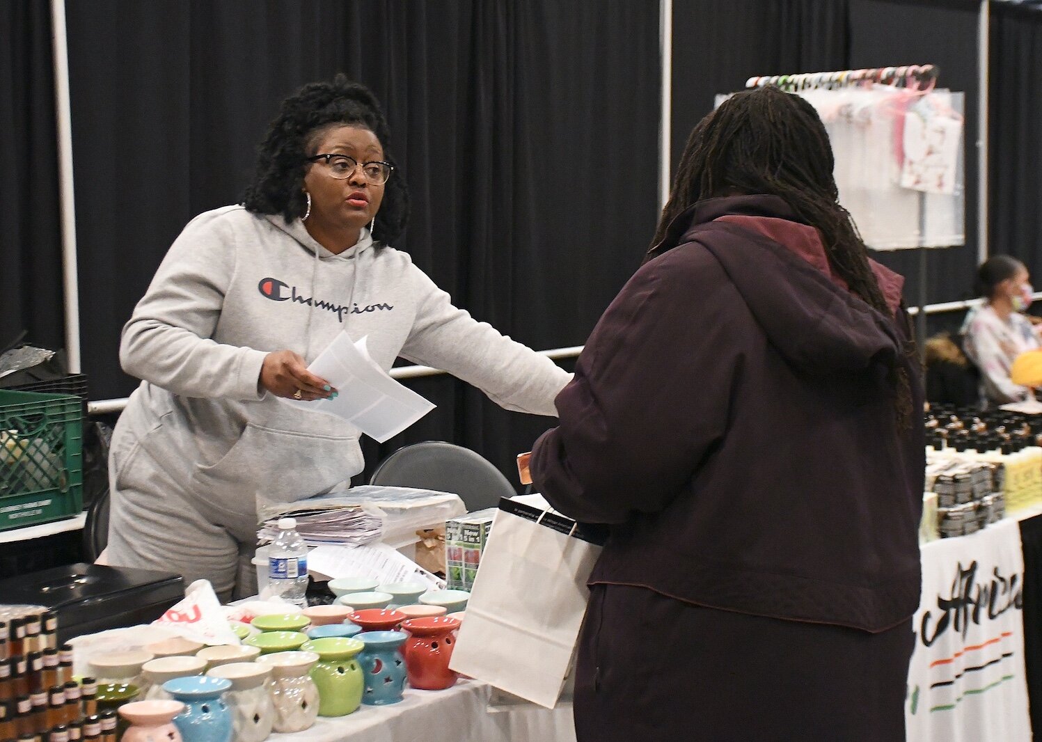 Regina Jacobs of T.J. Oils and Body Works talks with a customer at Monday’s “We, Us, Our: 55 Shades of Black” commemoration of Martin Luther King, Jr’s birthday.