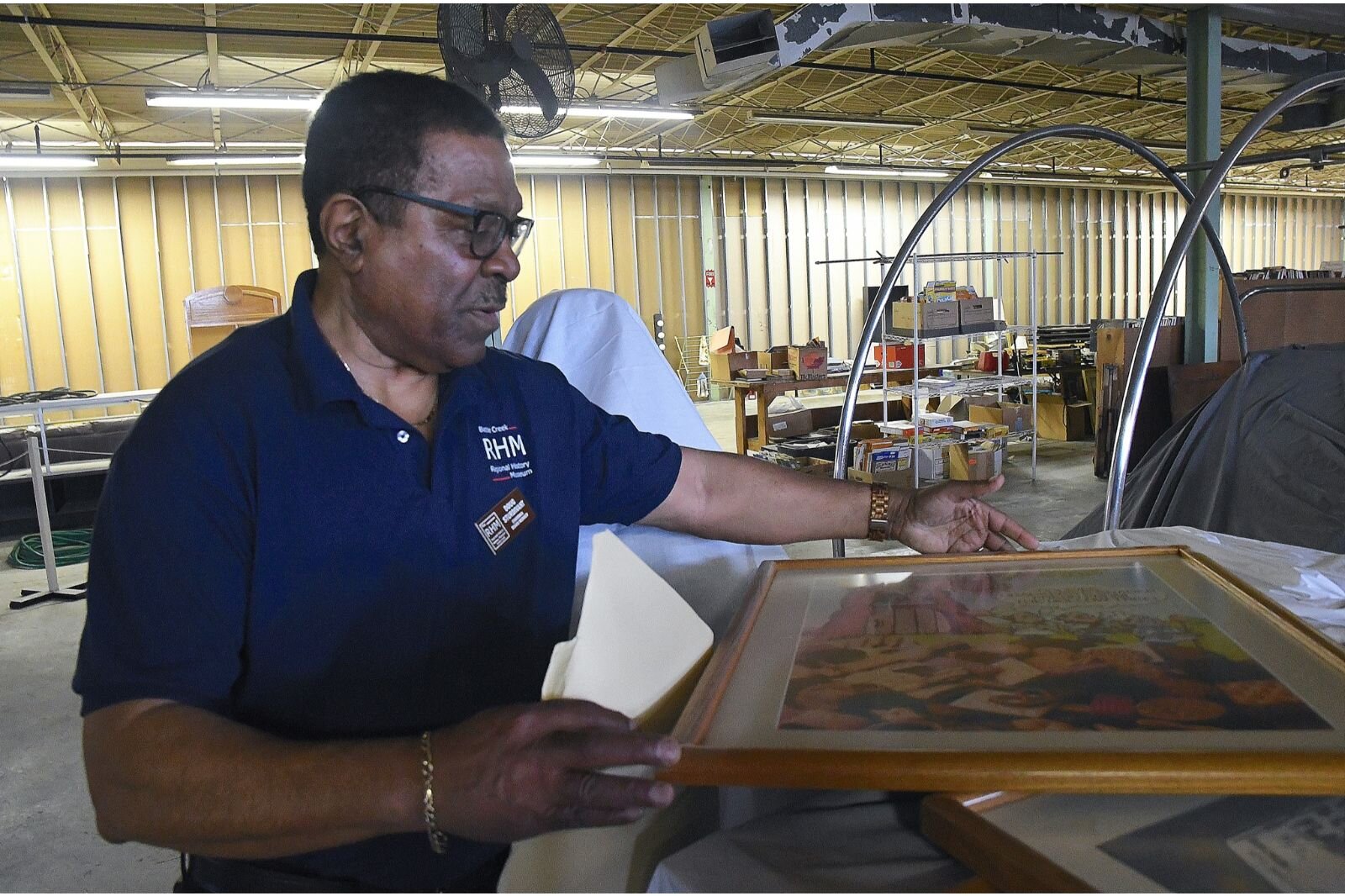 Doug Sturdivant, president of the Battle Creek Regional History Museum Board of Directors, looks at framed posters.