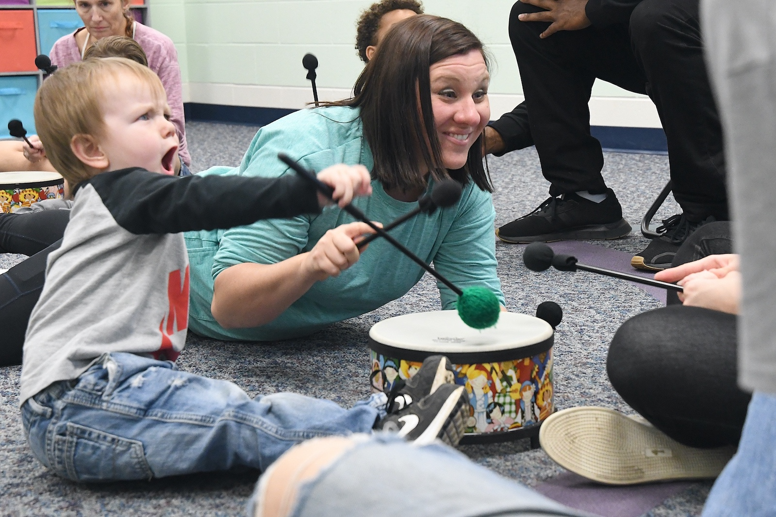 Asher Alexander, 2, shows off his drum skills while instructor Teri Noaeill encourages a younger sibling during a Music First session at the Music Center.