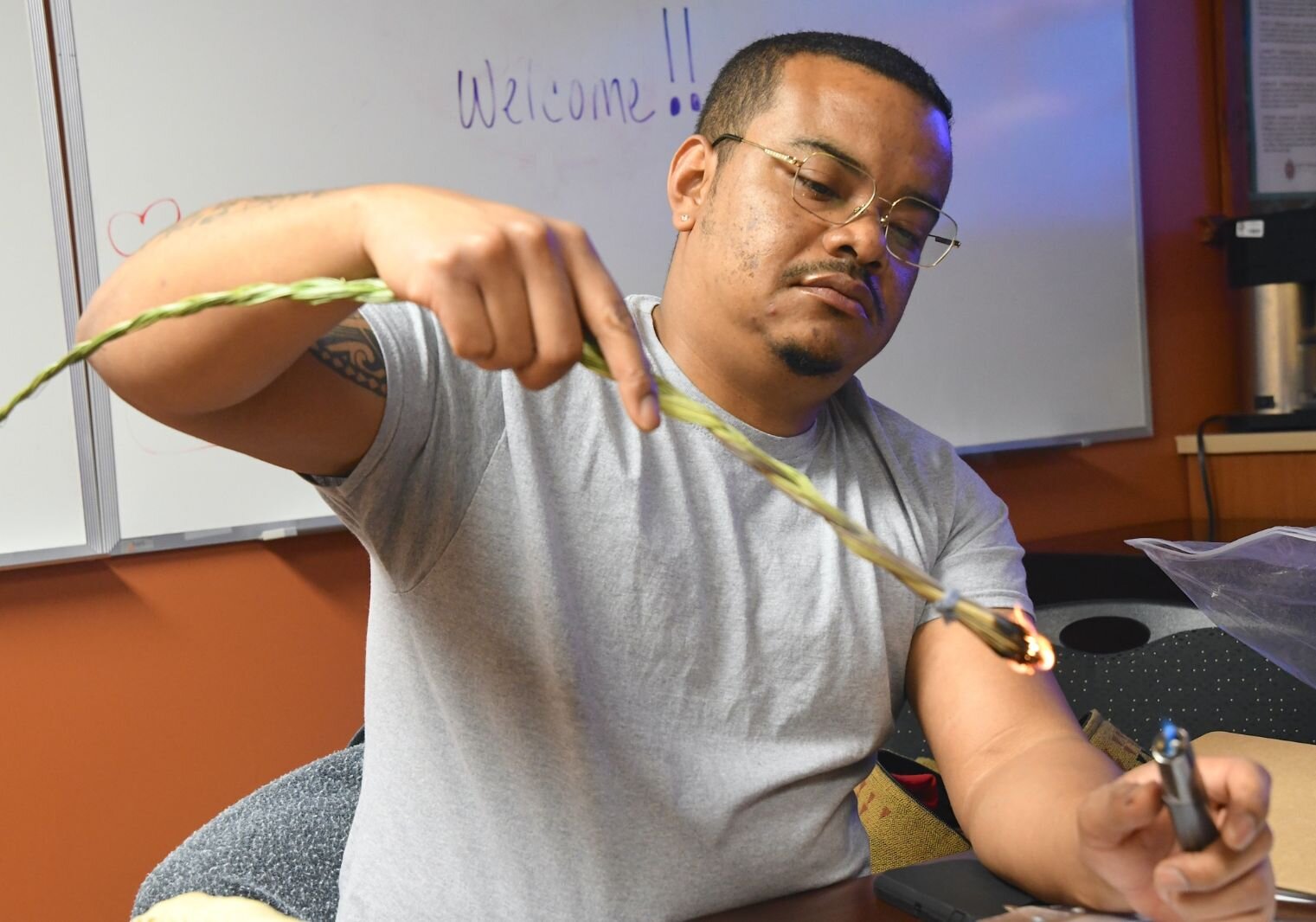 Andre Mandoka from the Cultural Department lights sage grass in the traditional healing room at the NHBP Health Center in Fulton.