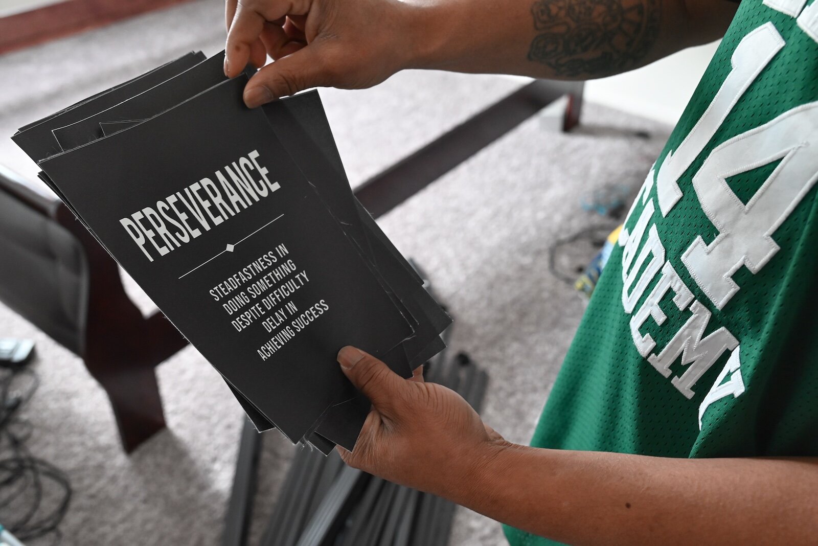 Quinton Bozell holds one of the many motivational posters he has.
