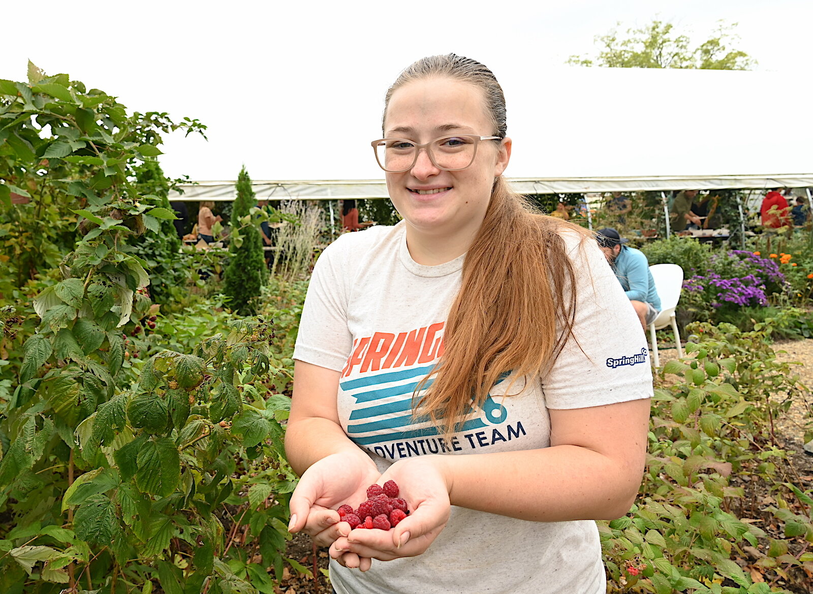 Stephanie Orr holds raspberries she picked during Of The Land’s harvest festival.