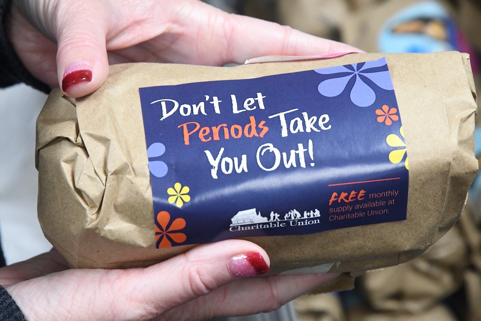 Teresa Allen, Chief Executive Officer of the Charitable Union, holds a monthly supply of feminine hygiene products.