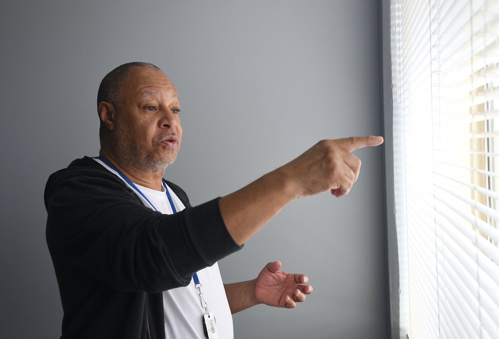 Lowell Wilson points to a wooded area where wildlife come, including deer, near Springview Towers.