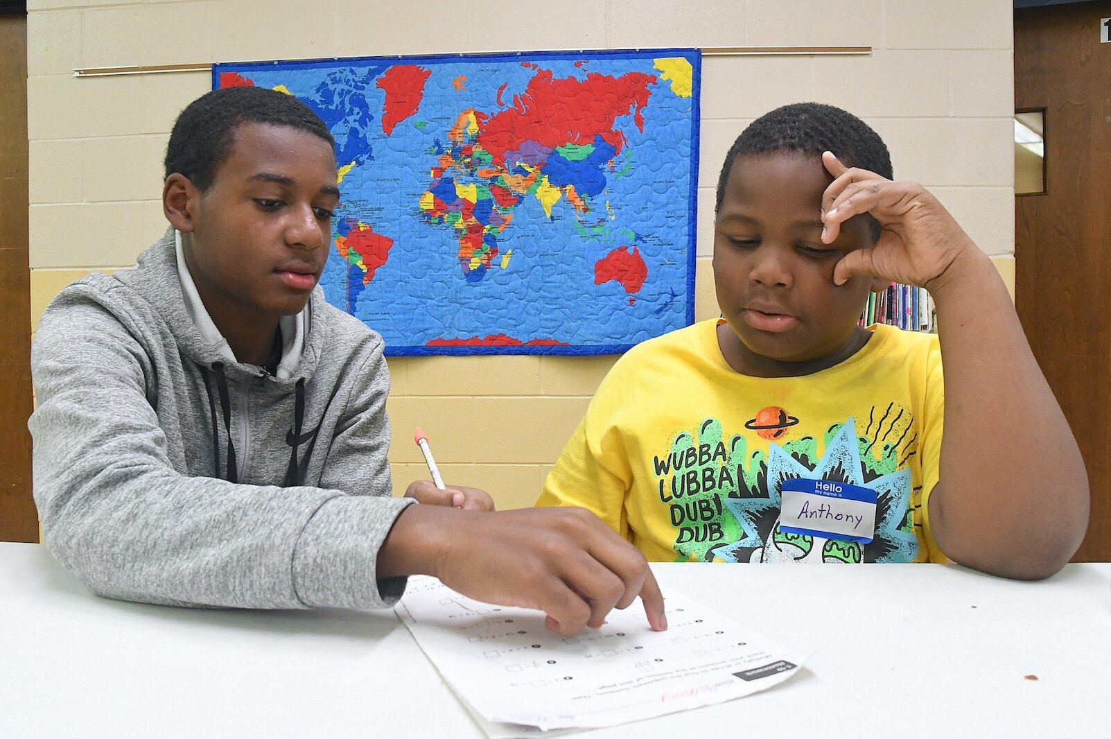 Xavier Thompson, left, a 10th grade student at Battle Creek Central High School, works with Anthony Bridges, 8, at Second Missionary Baptist’s after-school tutoring program.