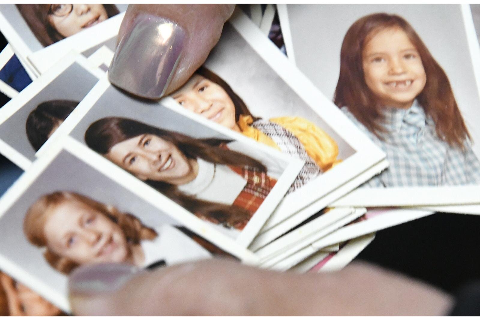 Sharon Skutt holds photos of students who were at Holy Childhood School of Jesus in Harbor Springs,