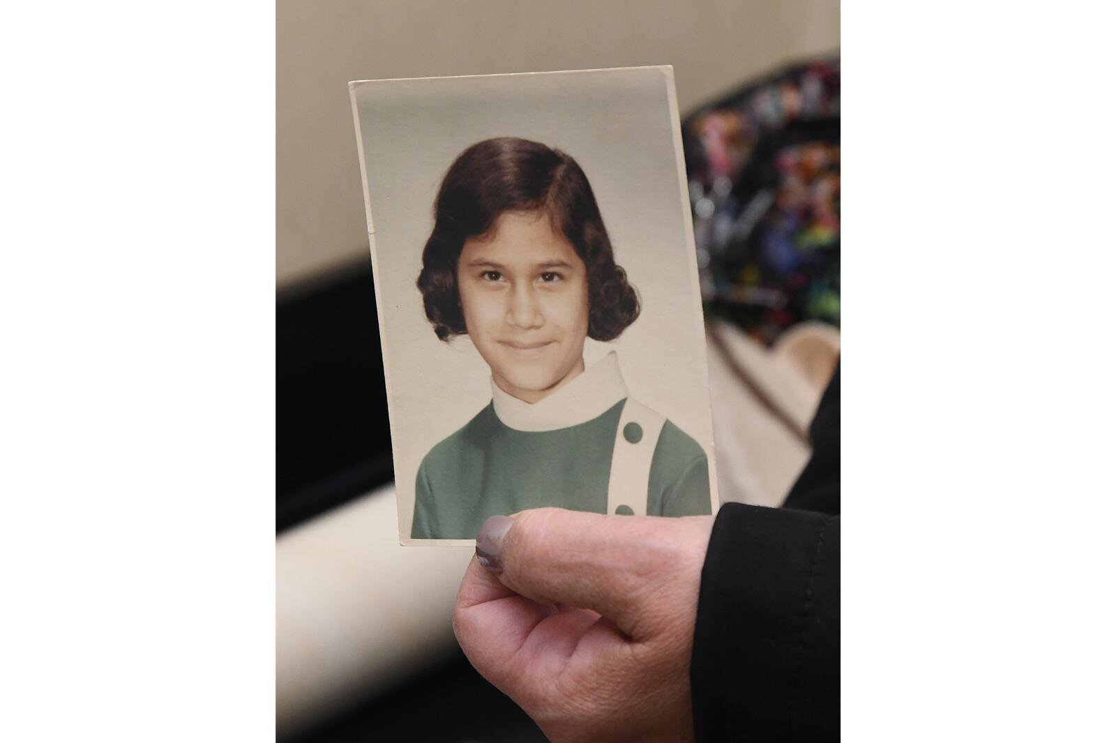 Sharon Skutt holds a photo of herself when she was a student at Holy Childhood School of Jesus in Harbor Springs.