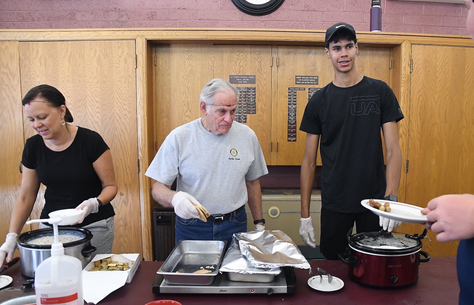 Rotary volunteers, from left, Lisa Ridgeway, Tom Ebeling, and Jayeden Walker serve breakfast at St. Thomas.