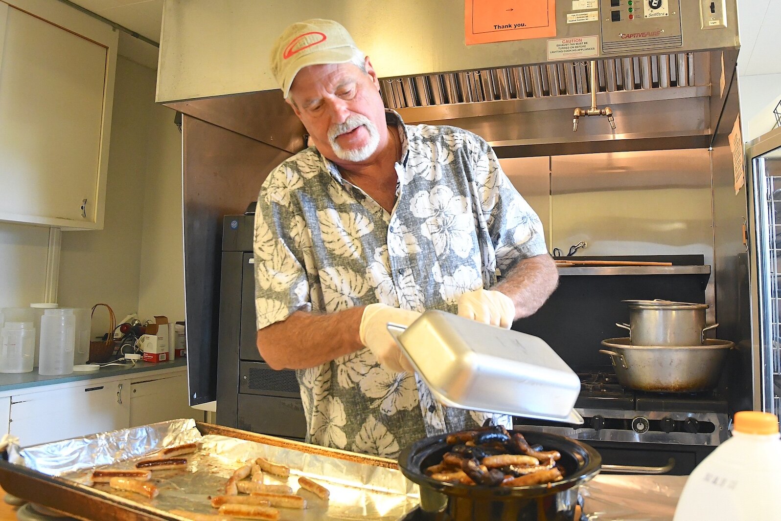 Volunteer Rock Kadlub, empties sausages Into a crock pot for serving, at St. Thomas Episcopal Church’s breakfast program.