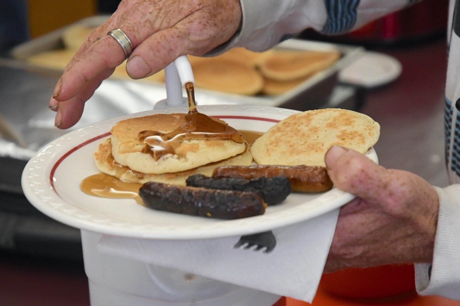 A customer pours syrup onto his pancakes at St. Thomas Episcopal Church’s breakfast program.