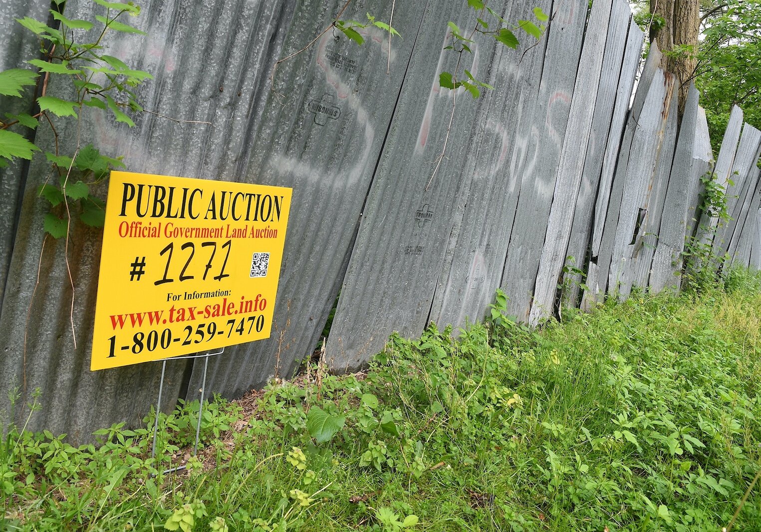 Public auction sign on a fence in front of property located on West Hamblin Avenue, just west of Butler Street, in Battle Creek