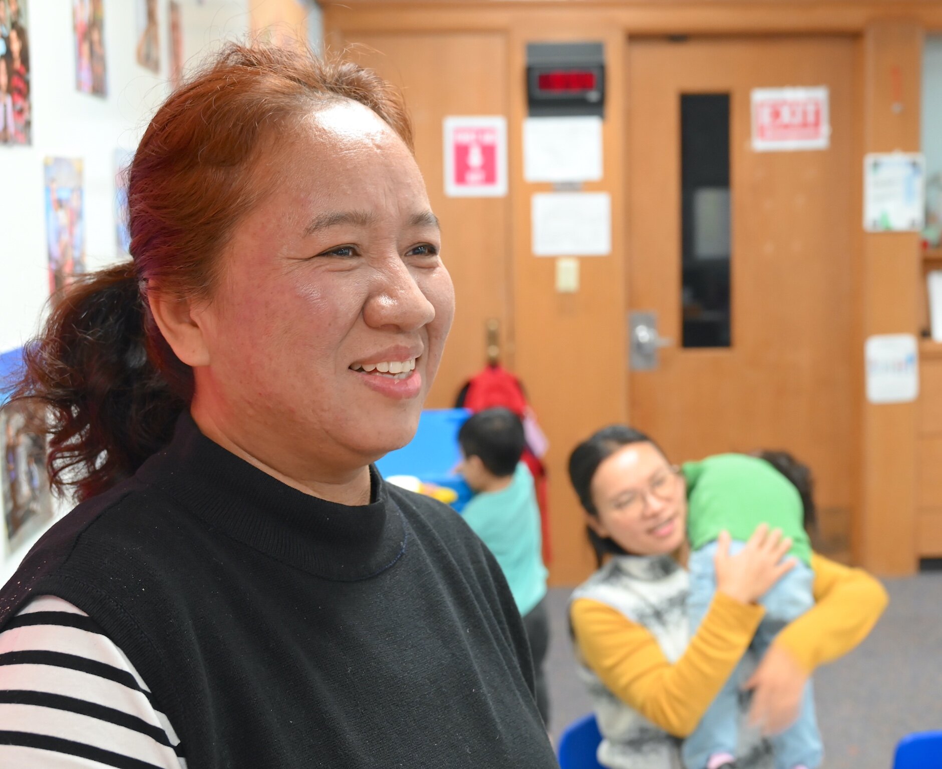 Khup Cing is seen in a room of young children at the Burma Center’s Dream Learning Center.