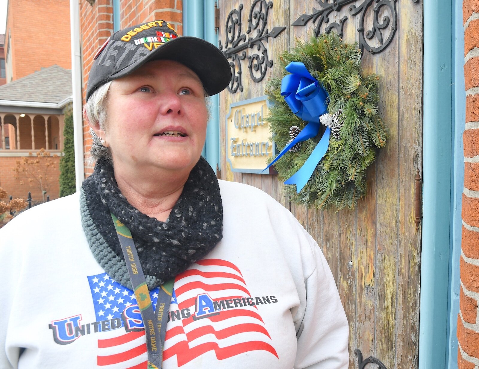 Mary Bourgeois, a U.S. Army veteran, stands in front of the entrance to the chapel at St. Thomas Episcopol Church.