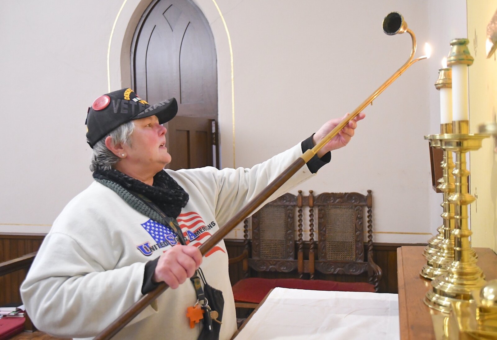 Mary Bourgeois, a U.S. Army veteran, lights a candle in the chapel at St. Thomas Episcopol Church.