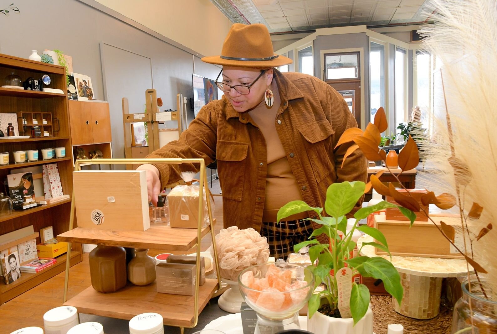 Tiffany Blackman sorts items on a shelf at her store in downtown Battler Creek.