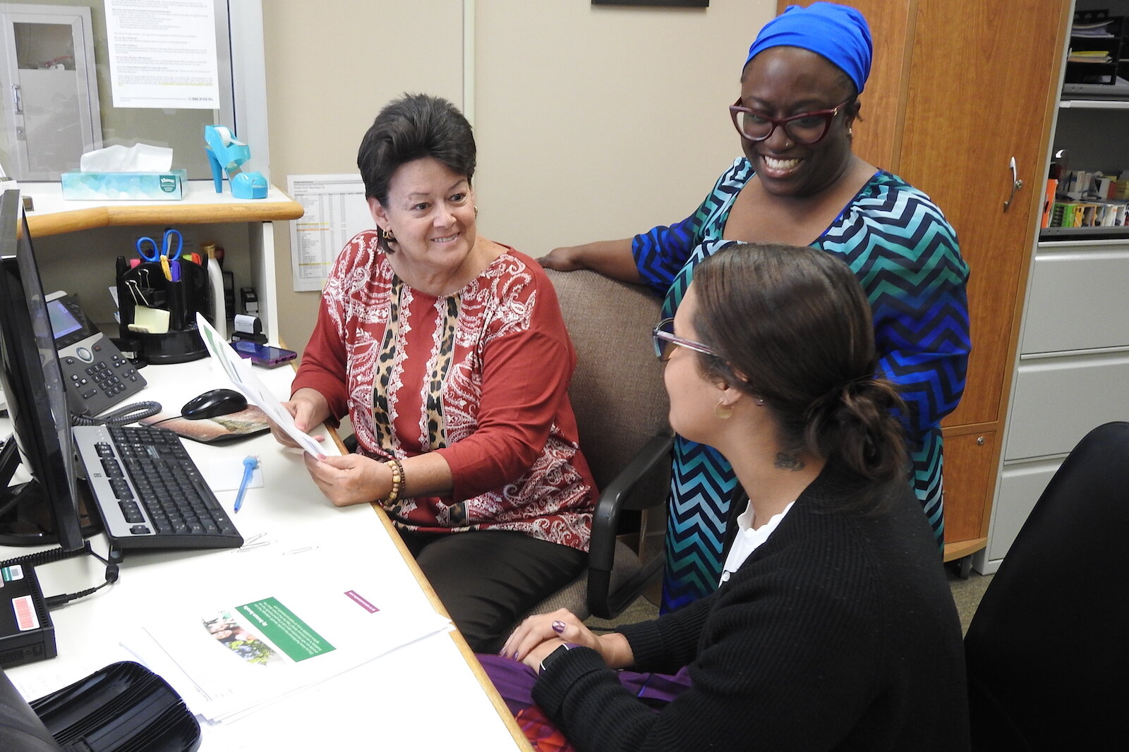 Elishae Johnson, system director of business health services at Bronson Healthcare, consults with Administrative Specialist Pam Milliron, left, and Information Specialist Lexi King at Bronson Battle Creek Psychiatry and Behavioral Health in May.