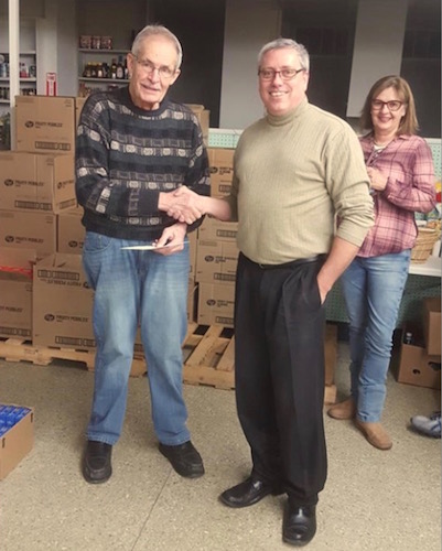 Cereal City Sunrise Rotary Past President Troy Wensauer presents a check to Fred Lutzke as part of a matching grant from the Rotary Foundation to asist the food bank.
