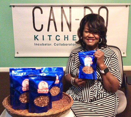 Doreen Gardner holds a bag of Papa’s Peanut Brittle that she’s producing at Kalamazoo‘s Can-Do Kitchen.