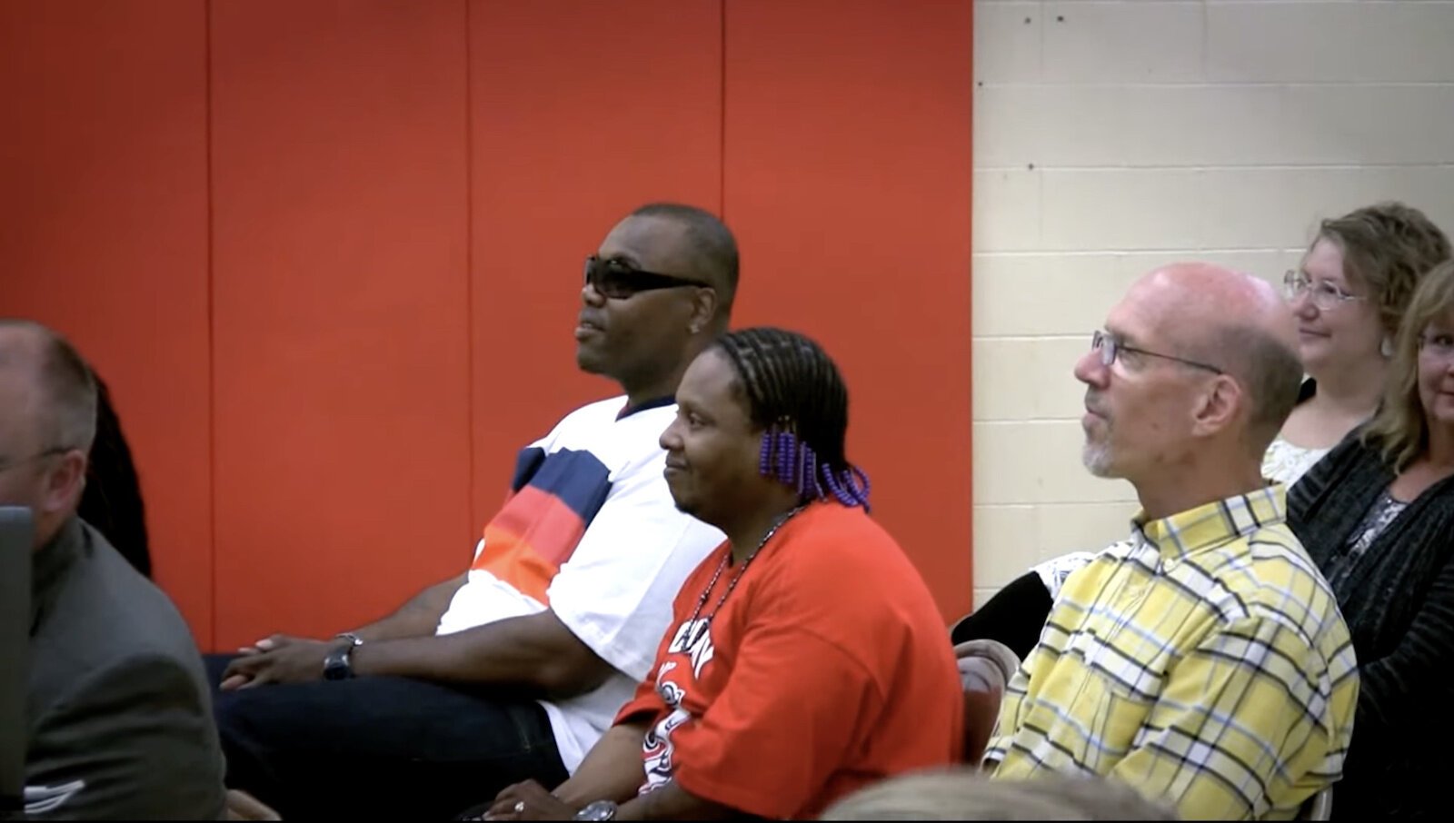 Michael Wilder (red shirt) and Yafinceio Harris attend a graduation ceremony for young people they worked with. From the mini-documentary Peace During War.