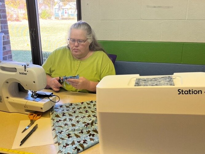 Penny Springer, who came to the Co-op one year ago, sits at her sewing machine making ornaments that she will sell at holiday craft fairs and bazaars.