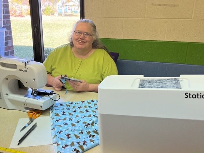 Penny Springer, who came to the Co-op one year ago, sits at her sewing machine making ornaments that she will sell at holiday craft fairs and bazaars.