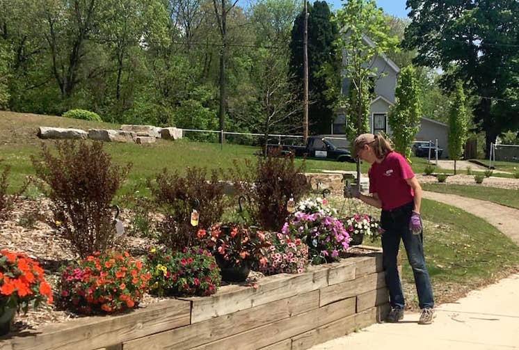 C. J. Drenth plants flowers in the new Eastside Pocket Park. 