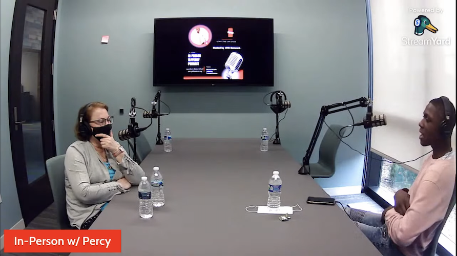 Percy Gordon sits with Kydnet executive director Meg Blinkiewicz in the Kalamazoo Promise podcast recording room during a filming of In Person With Percy.