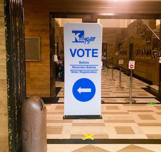 Signs are being used to guide people who want to vote early in the Nov. 3 general election at the Kalamazoo City Clerk’s Office. They are shown inside Kalamazoo City Hall in downtown Kalamazoo.