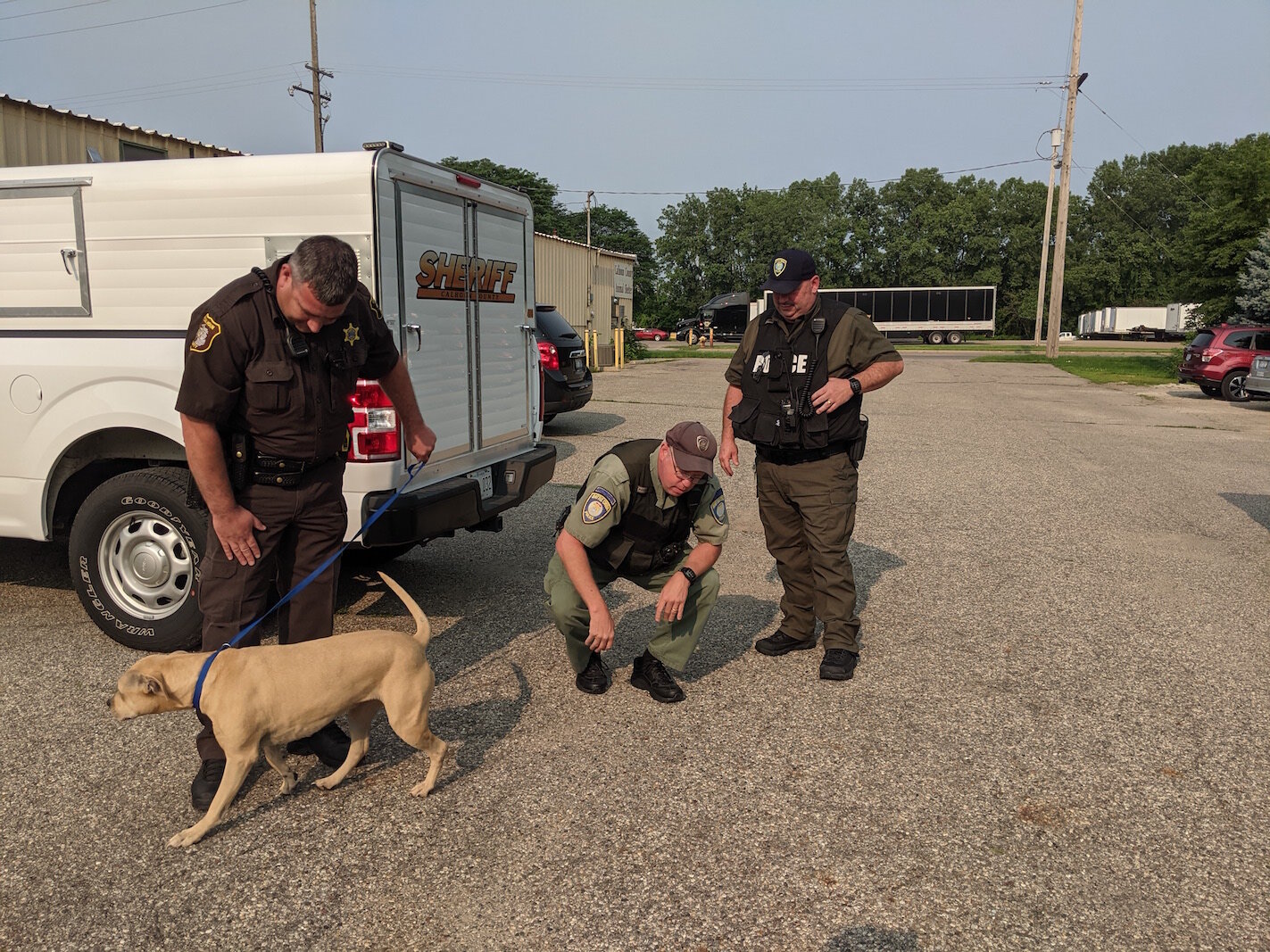 Photo 3:  Deputy Michael Vanderbilt prepares to walk a dog back inside the shelter as Officers Michael Ehart and Pat Dellinger watch.