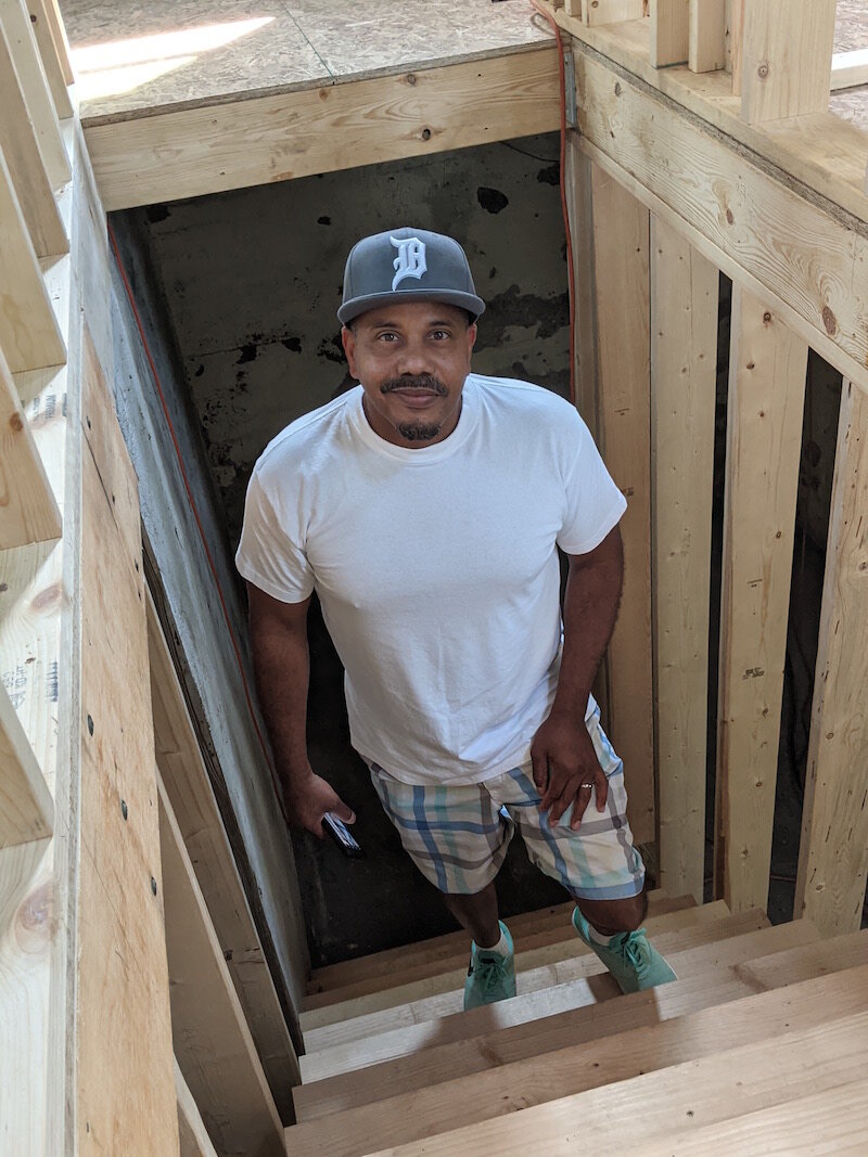 Raul Maysonet, founder and pastor of Hood Church, stands on steps going down to the basement of Hope House.