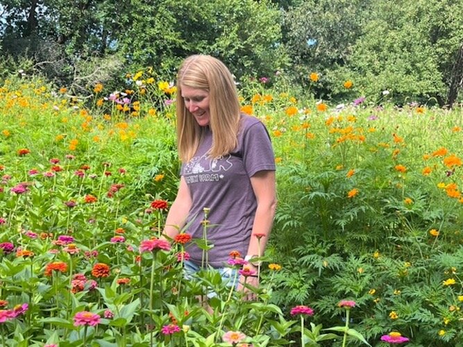 Rebekah Laupp looking at zinnias that are among several varieties of flowers growing in their U-pick flower garden