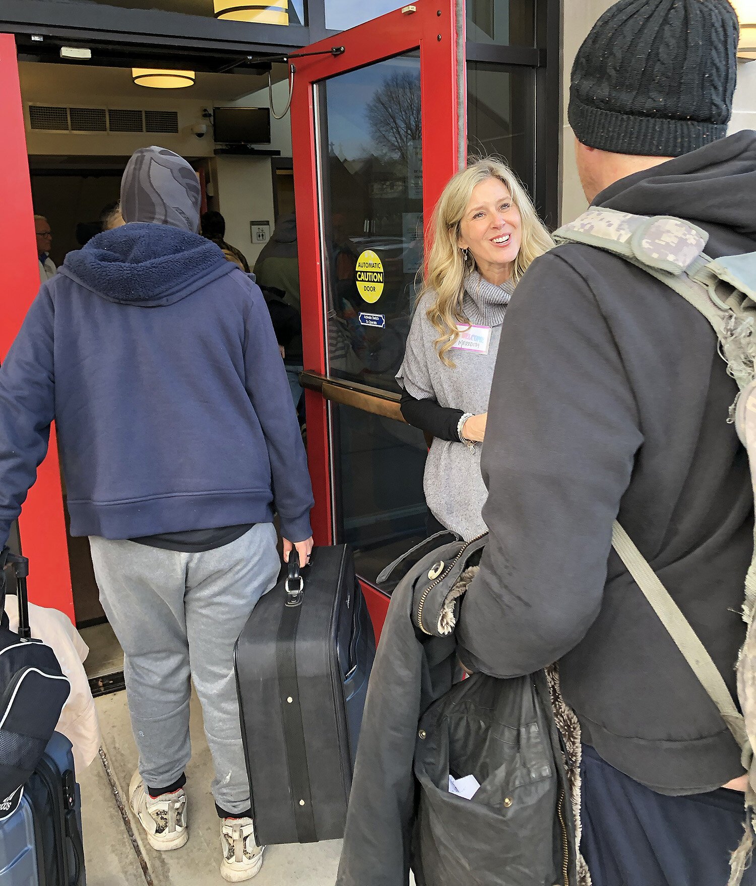 Meredith Alspach welcomes people entering the church’s rear door.