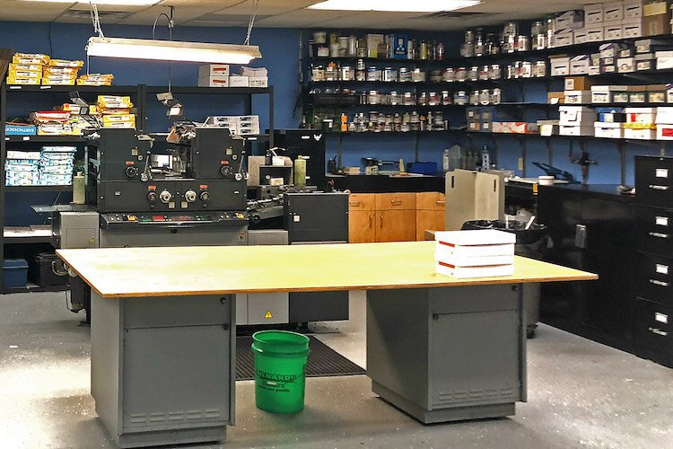 A press is best for some work. This is the press room with shelves holding cans of ink and reams of paper.