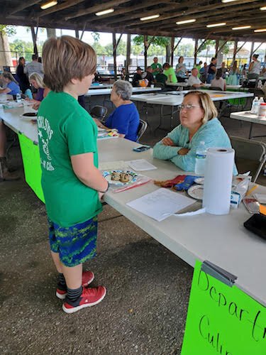 Ryder Strunk, age 9, talks with a judge about the process he used to make cookies that he entered in last year’s Calhoun County Fair.