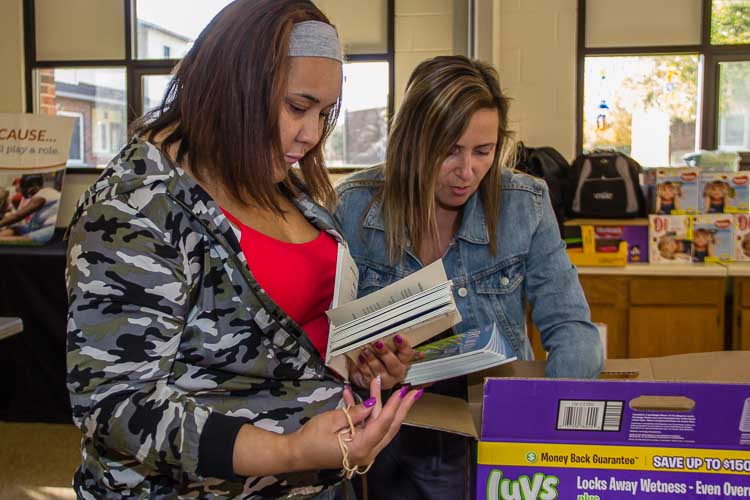 Aliyah looks over books available at a recent diaper distribution.