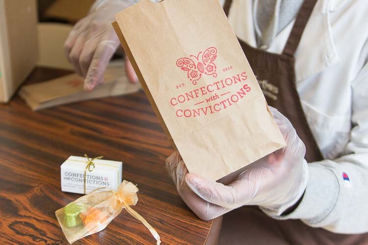 Employee Sincere Rostick packing up treats from Confections with Convictions 
