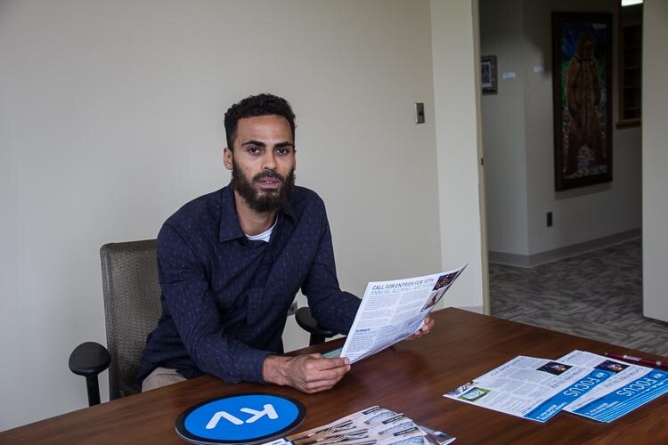 Jacob Pinney-Johnson looks at KVCC educational materials in the Kalamazoo Defender office. The office connects a network of social and human service organizations that are set to try to meet the needs of indigent defendants.