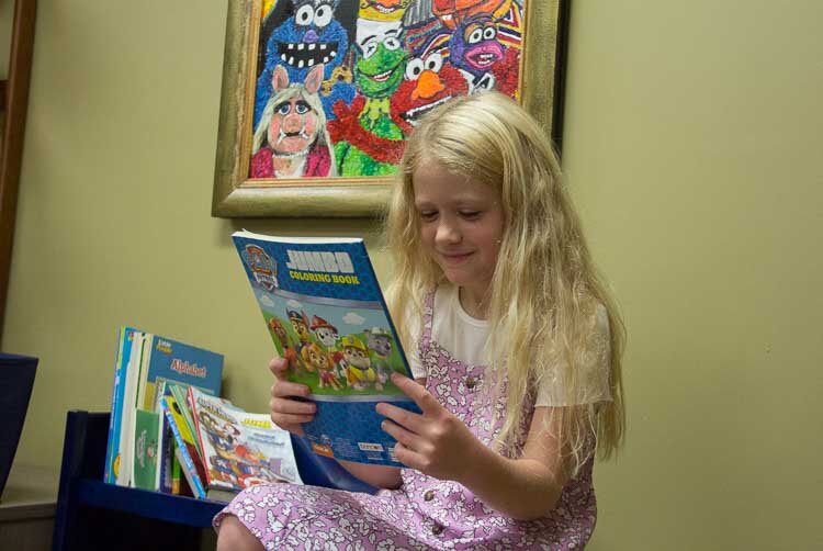  A child looks at materials in the Child Area for clients with children.