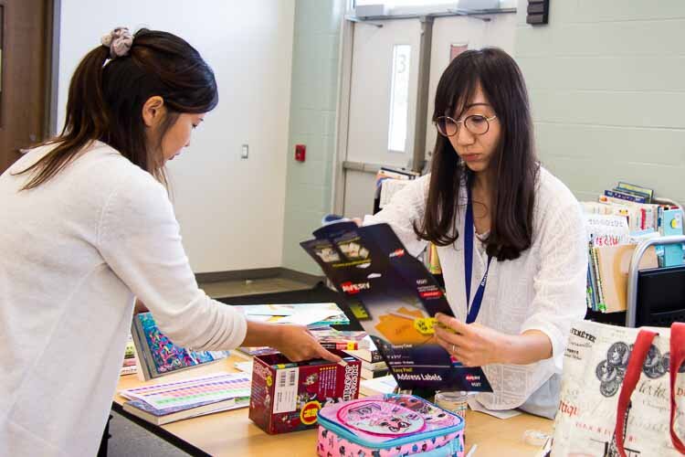 Mothers Mrs. Natsuko Nakao, left, and Mrs. Kaori Kanazawa sort books at lunchtime.