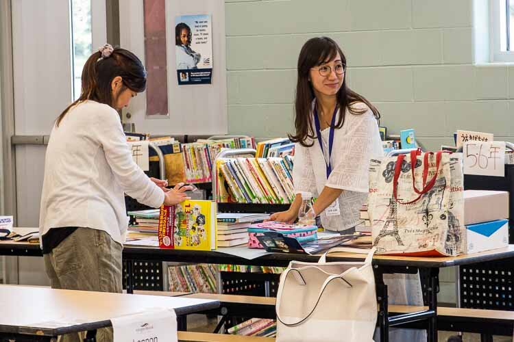 Mothers Mrs. Natsuko Nakao, left, and Mrs. Kaori Kanazawa sort books at lunchtime.