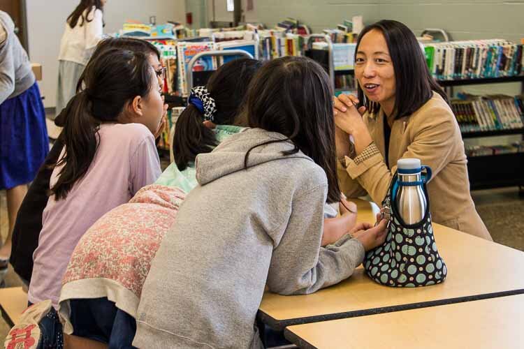 Teacher Michiko Yoshimoto chats with students at lunch. 