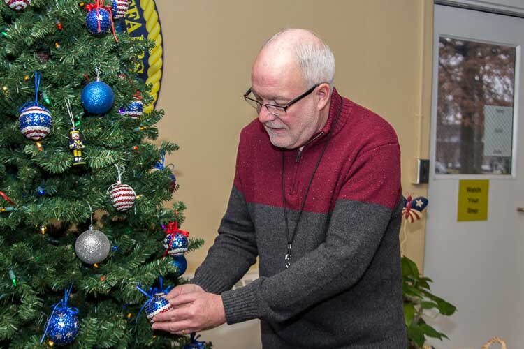 Todd Greenman, VHA-CM Chief, Community and Volunteer Service helps to decorate the Christmas tree.