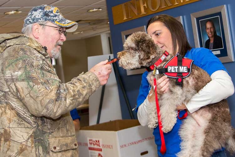 Brittany Gervais’s therapy dog Lucy gives doggy kisses to veterans.