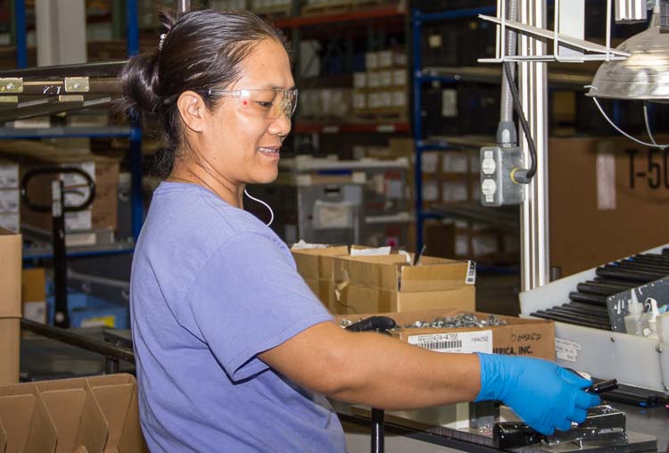 Tin Nawn at work at Steward Industries. She is learning English in a class offered in the workplace.