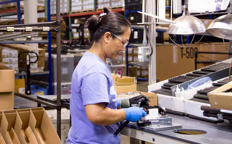 Tin Nawn at work at Steward Industries. She is learning English in a class offered in the workplace.